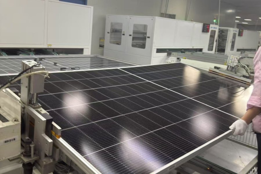 Technician performing final visual inspection on a solar panel before shipment