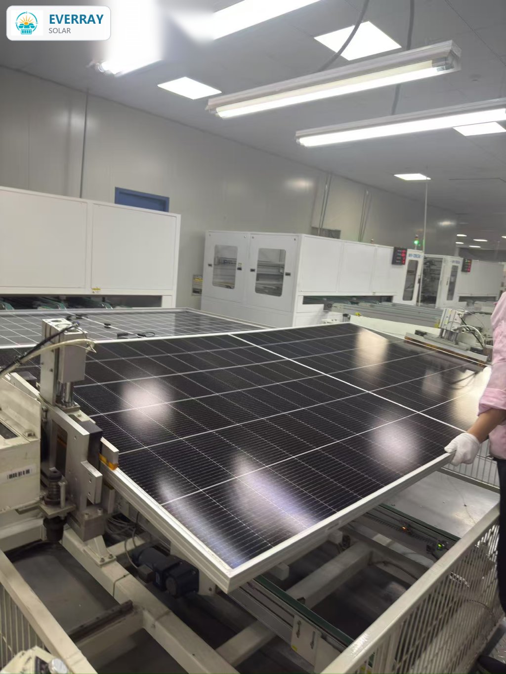 Factory technician performing visual inspection on a finished solar panel before shipment